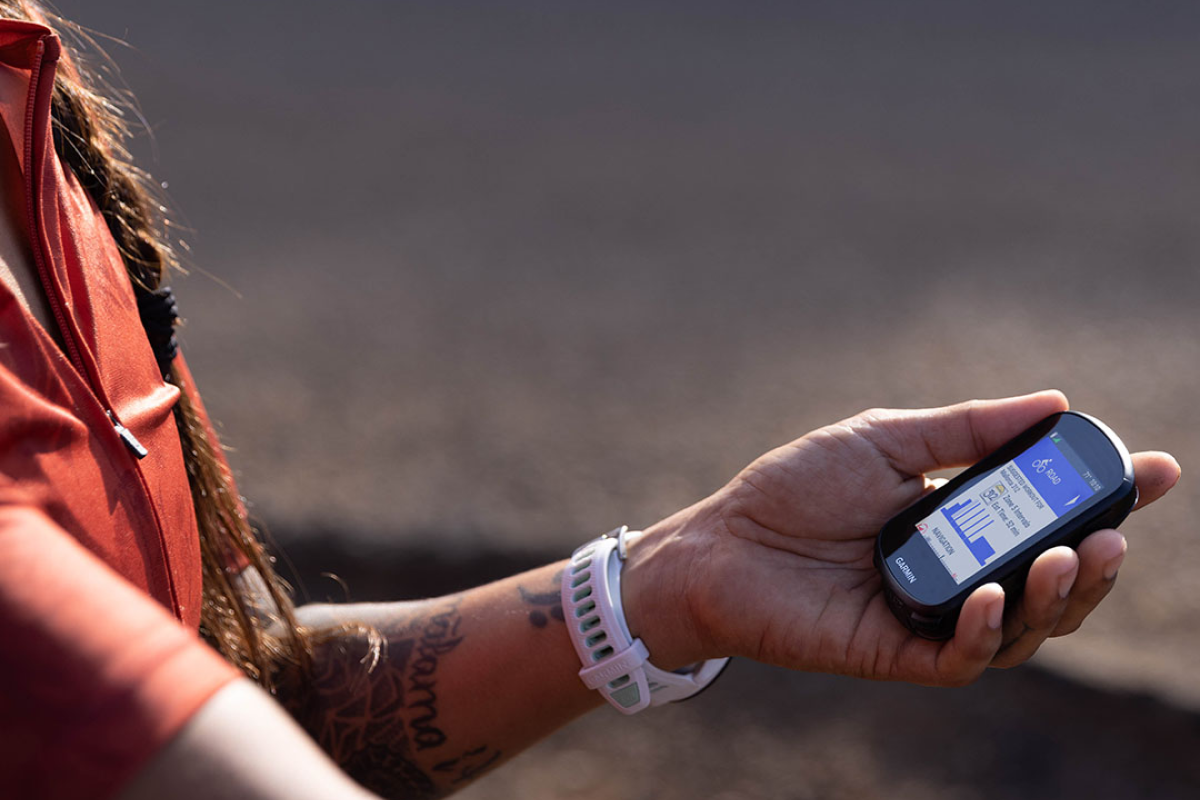 Osoba trzymająca w ręku licznik rowerowy Garmin
