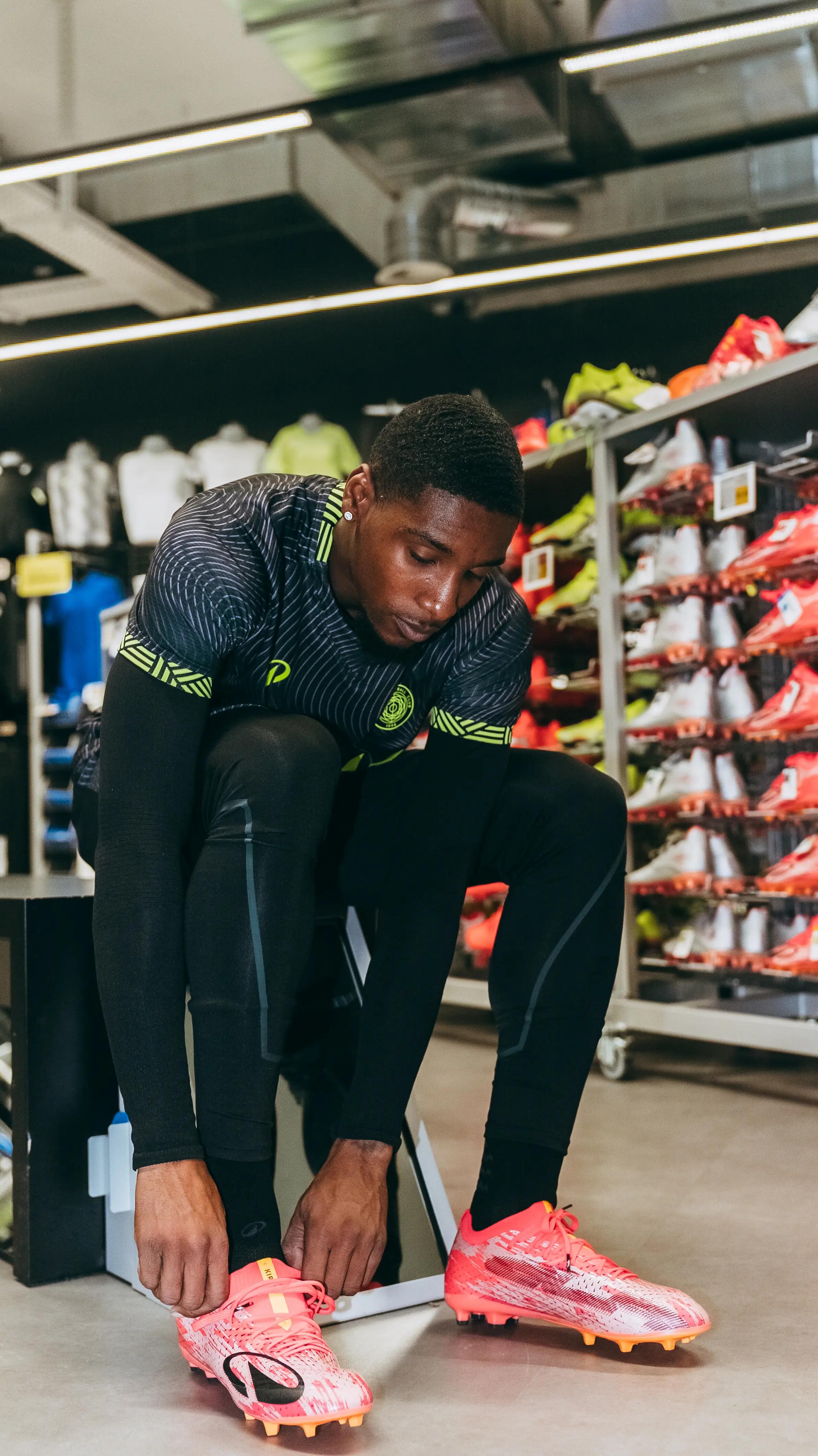 Ein Fußballer schnürt sich die Decathlon Fußballschuhe