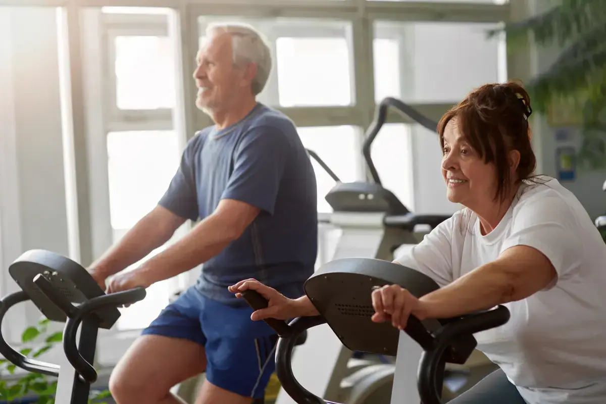 Seniorzy ćwiczący na rowerach stacjonarnych