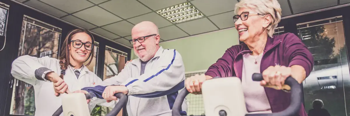 Osoby starsze ćwiczące na rowerach stacjonarnych do rehabilitacji