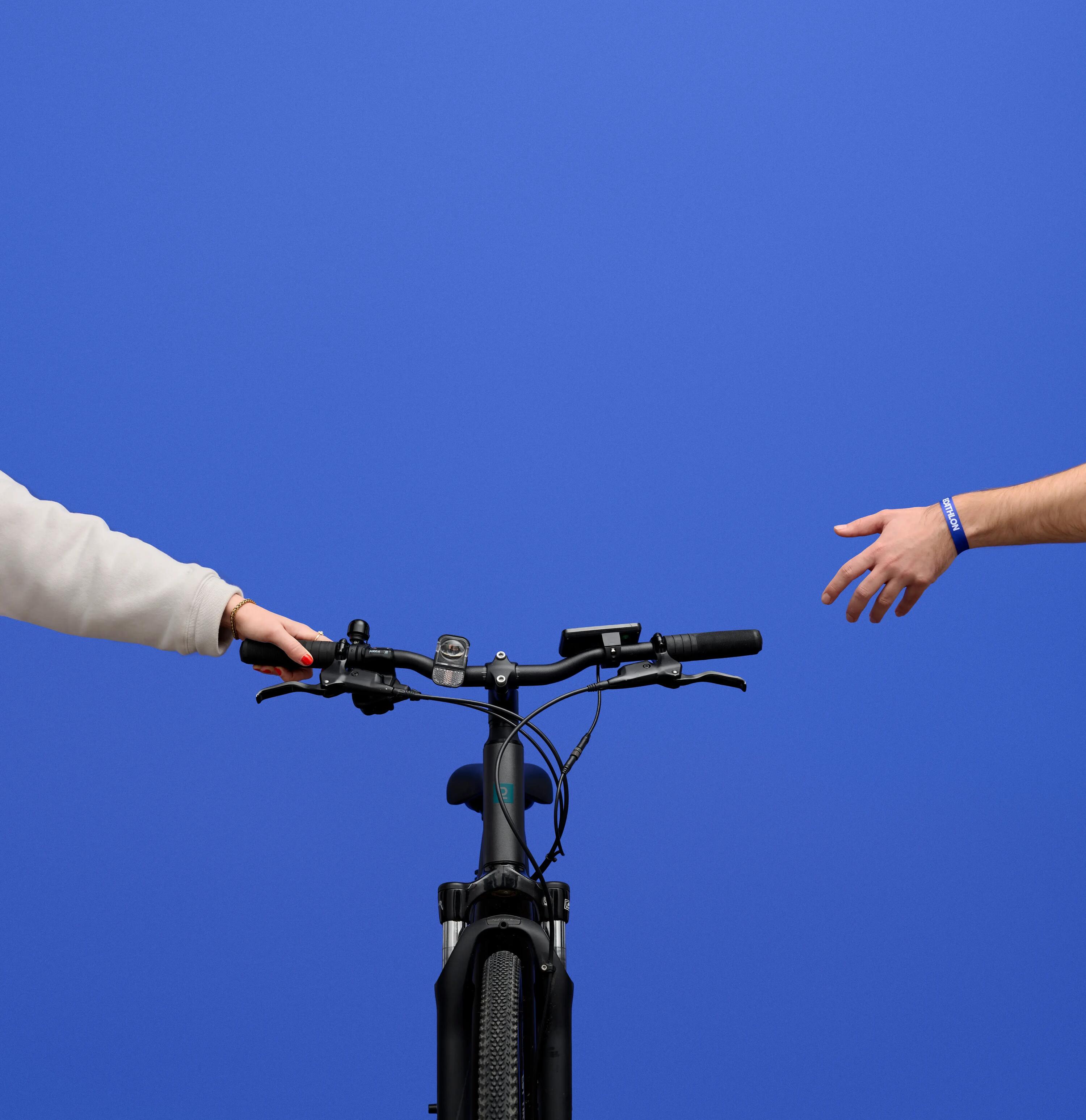 Zwei Hände von der seite halten des Fahrrad mit blauen Hintergrund.