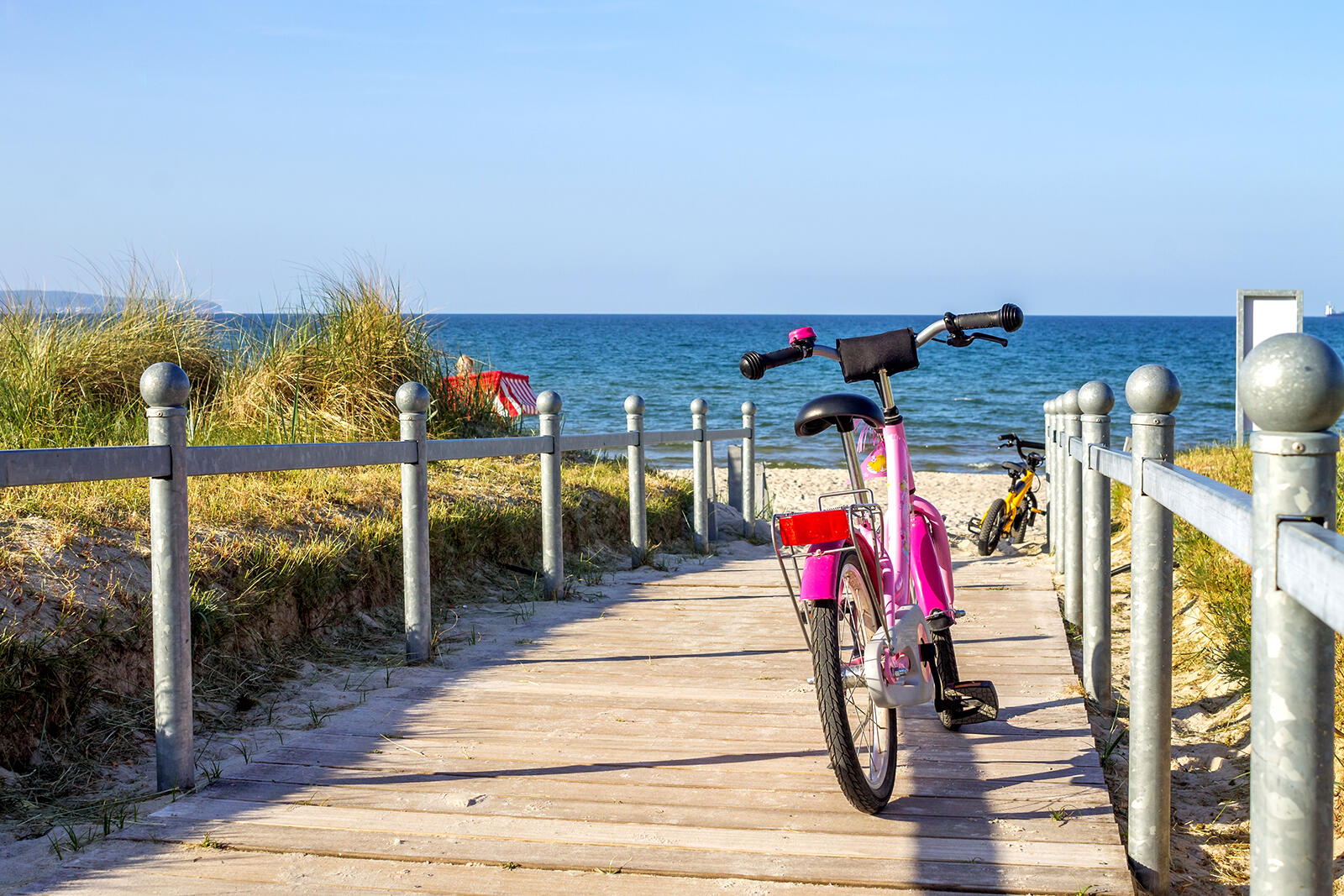 Rowerki dziecięce stojące na kładce przed zejściem na plaże