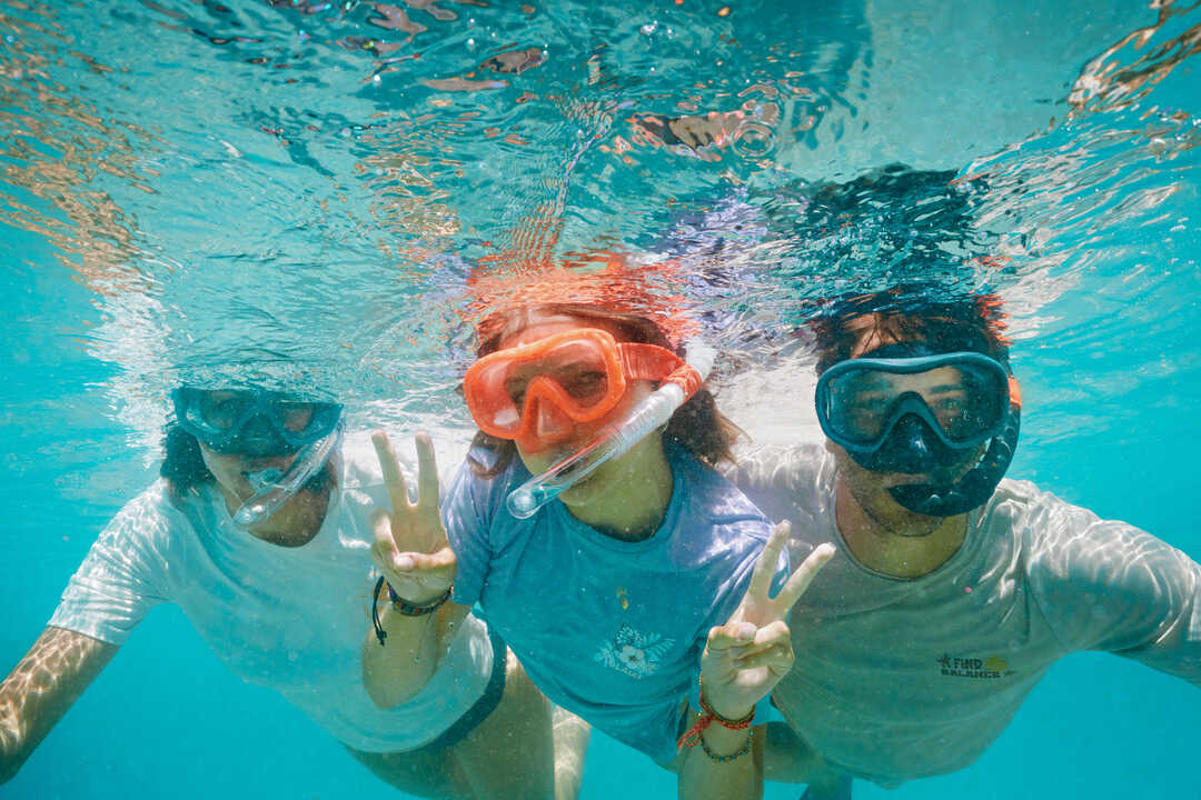 Troje ljudi pod vodom sa maskama za ronjenje