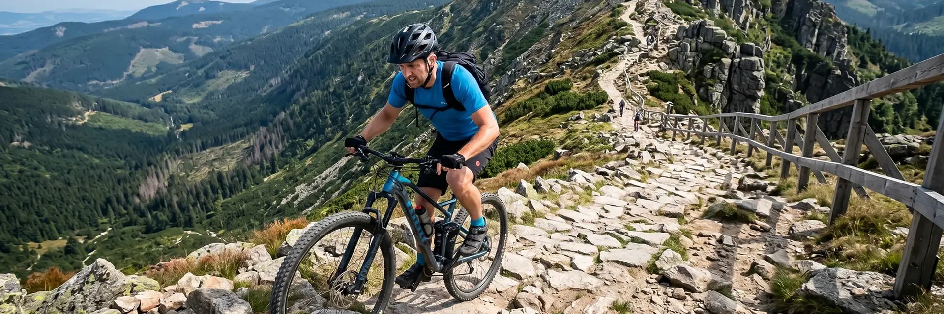 Rowerzysta w kasku z plecakiem jadący rowerem po trasie rowerowej w Karkonoszach