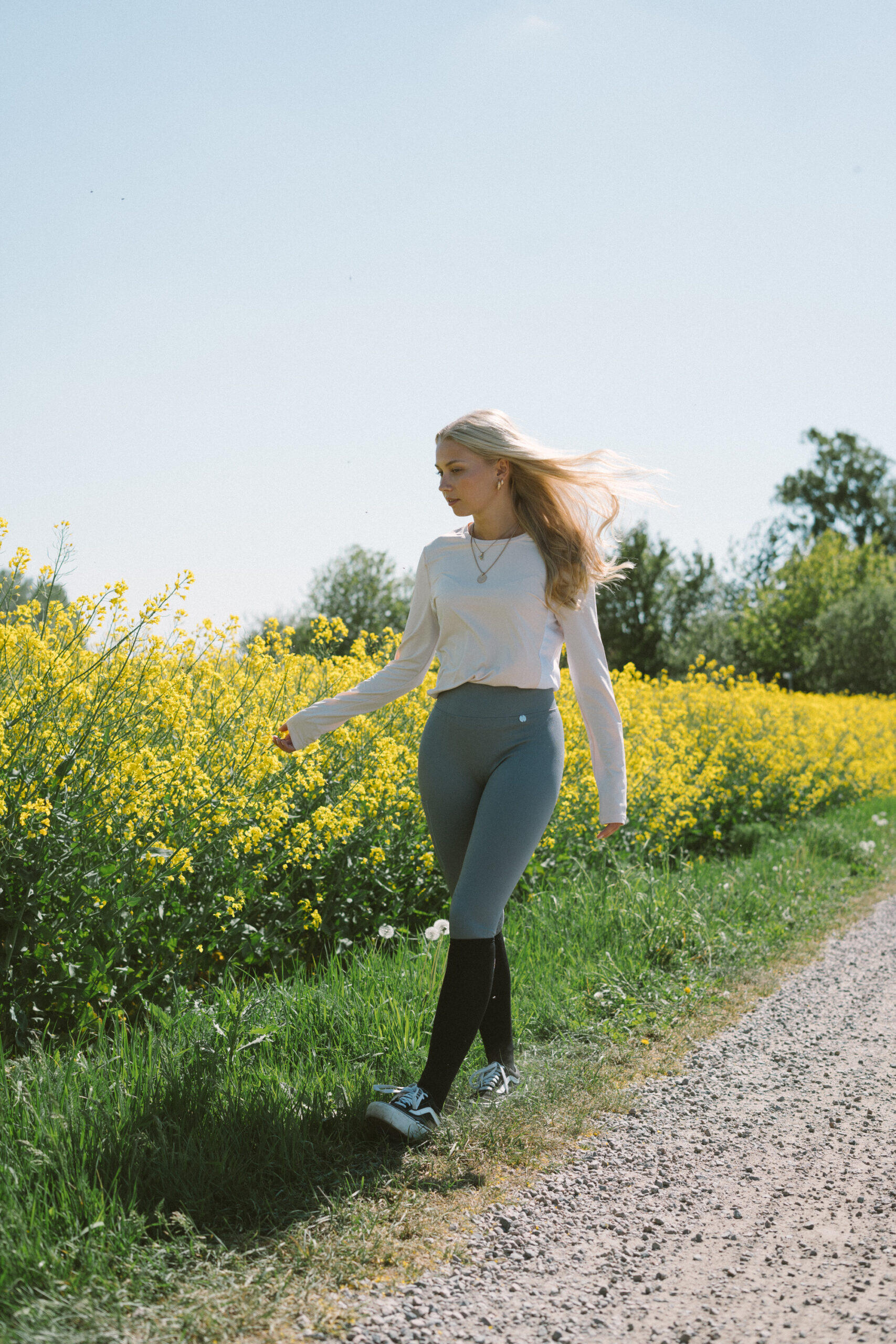Vrouw met paardrijleggings in een bloemenveld
