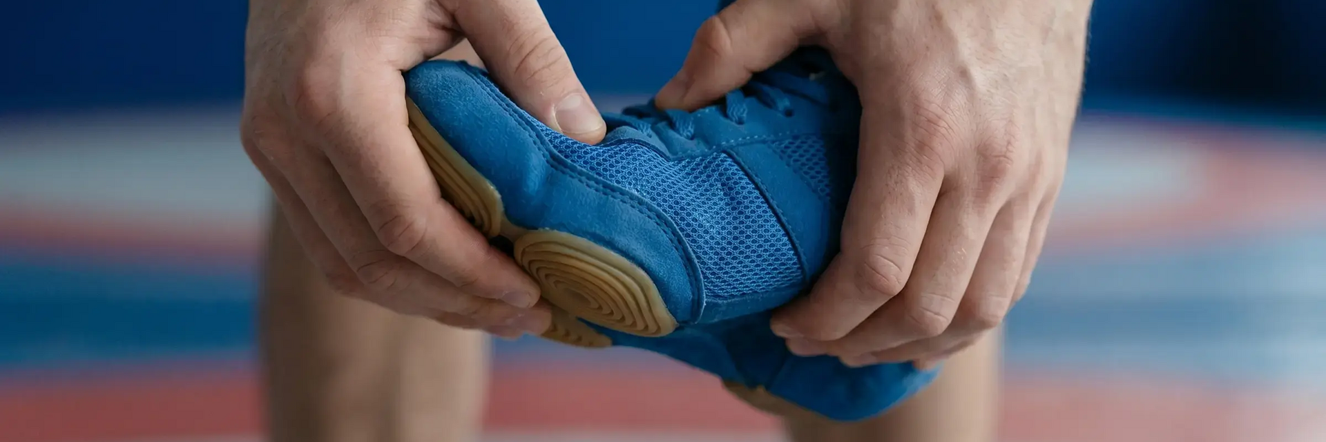 Mężczyzna ściskające w rękach buty zapaśnicze