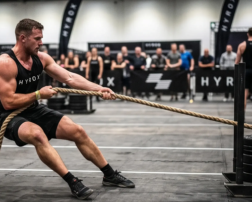 Mężczyzna ciągnący sanie sled pull podczas Hyrox