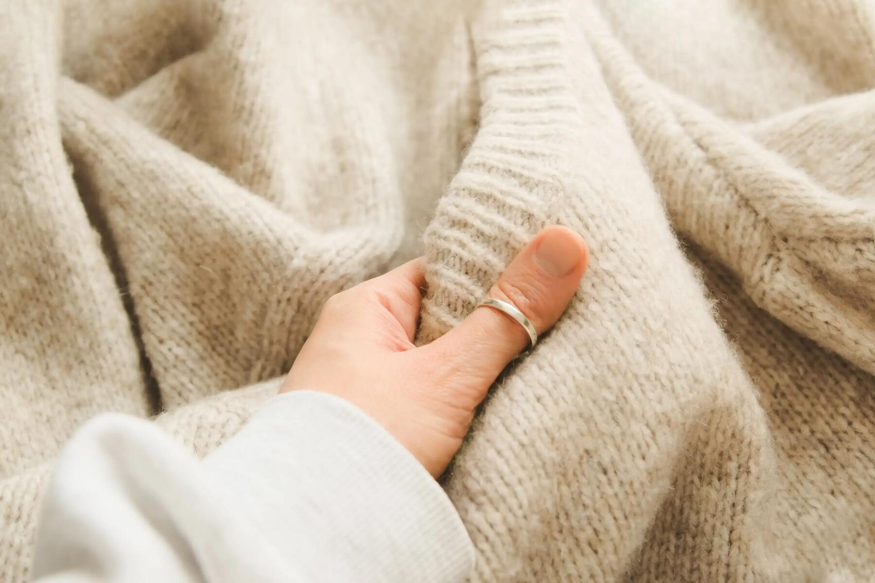 Kobieta dotykająca sweter z alpaki