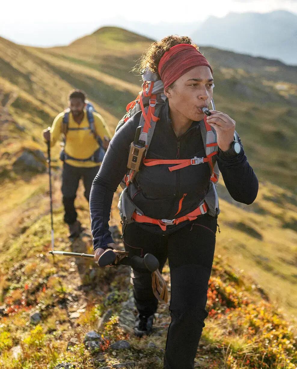 Ein Paar beim Wandern in den Bergen mit der Ausrüstung von Decathlon