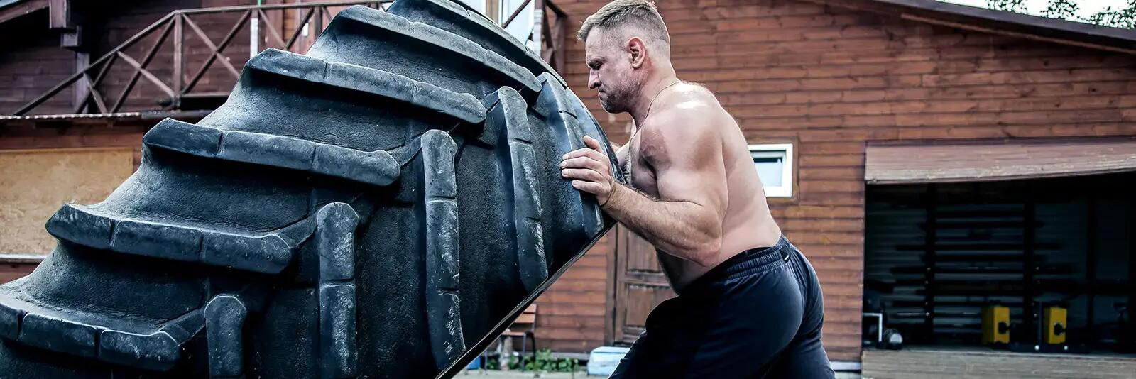 Mężczyzna trenujący przerzucanie opony