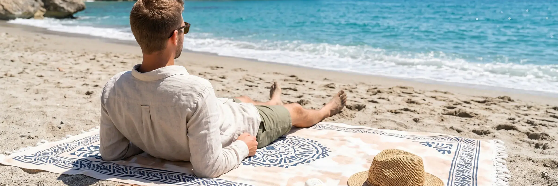 Mężczyzna leżacy na kocu na plaży w Hiszpanii