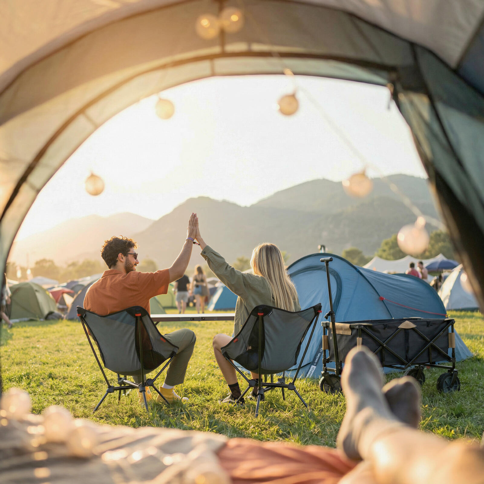 Man en vrouw halen zitten op een campingstoel op een festival en geven elkaar een high five.