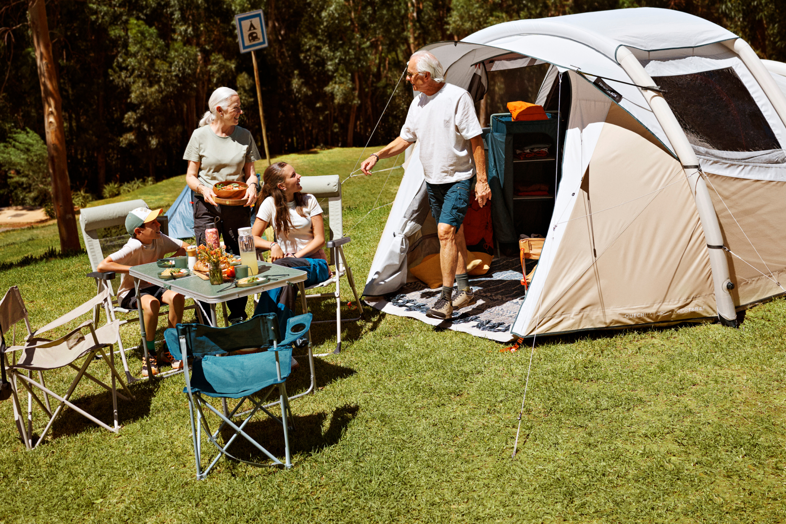 Campingurlaub: eine Familie auf dem Campingplatz vor ihrem Zelt