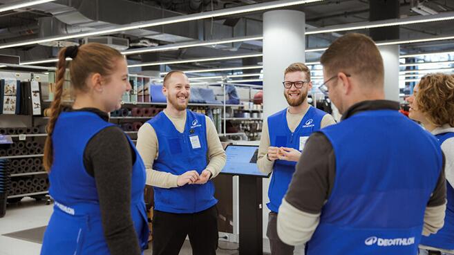 Ein Decathlon Team im Store bestehend aus vier Personen die alle sehr glücklich wirken