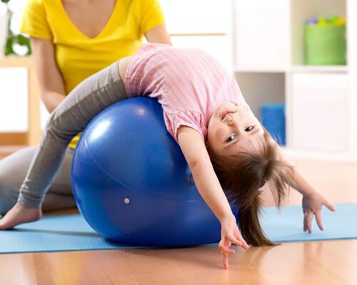 Dziewczynka ćwicząca na piłce pilates dla dzieci