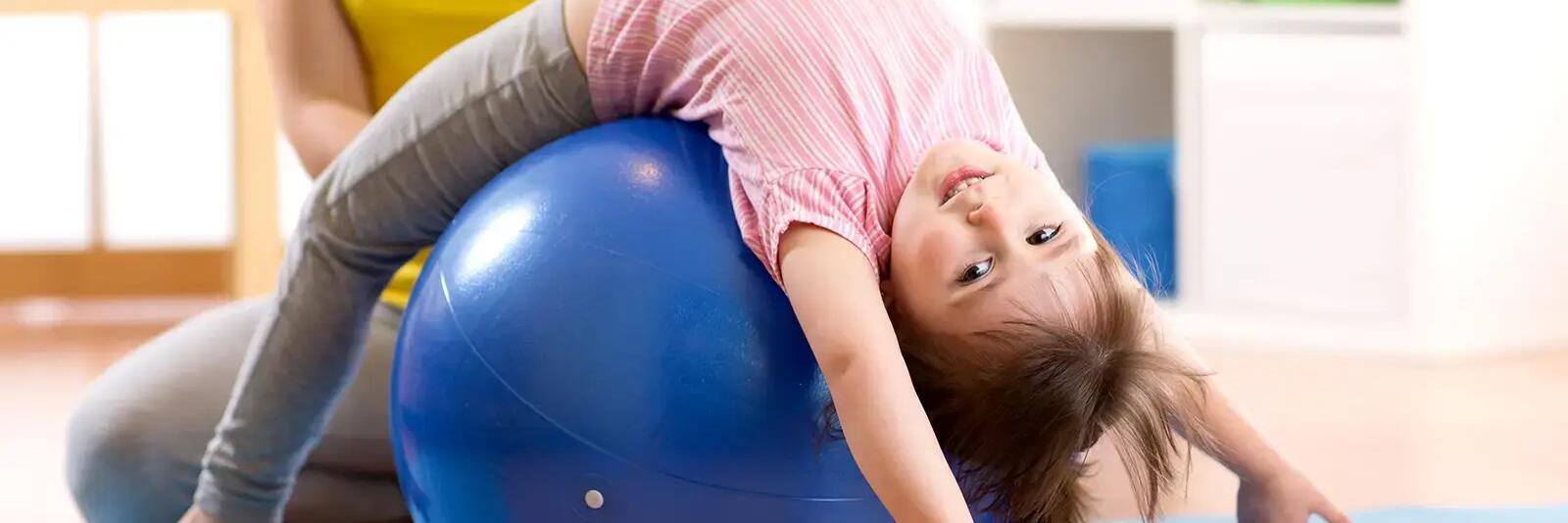 Dziewczynka ćwicząca na piłce pilates dla dzieci
