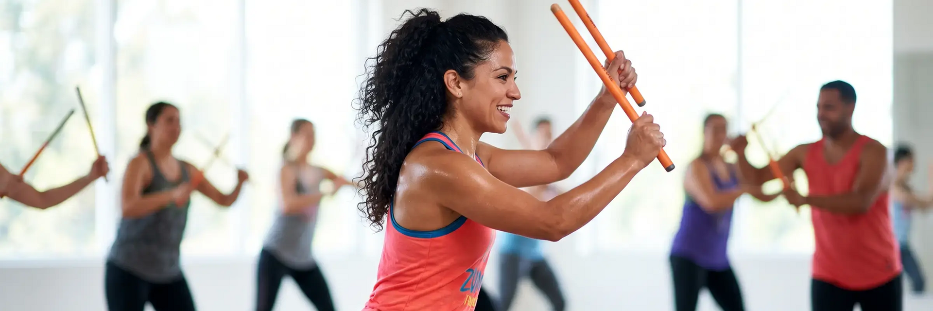 Ludzie ćwiczący z instruktorką zumbę toning