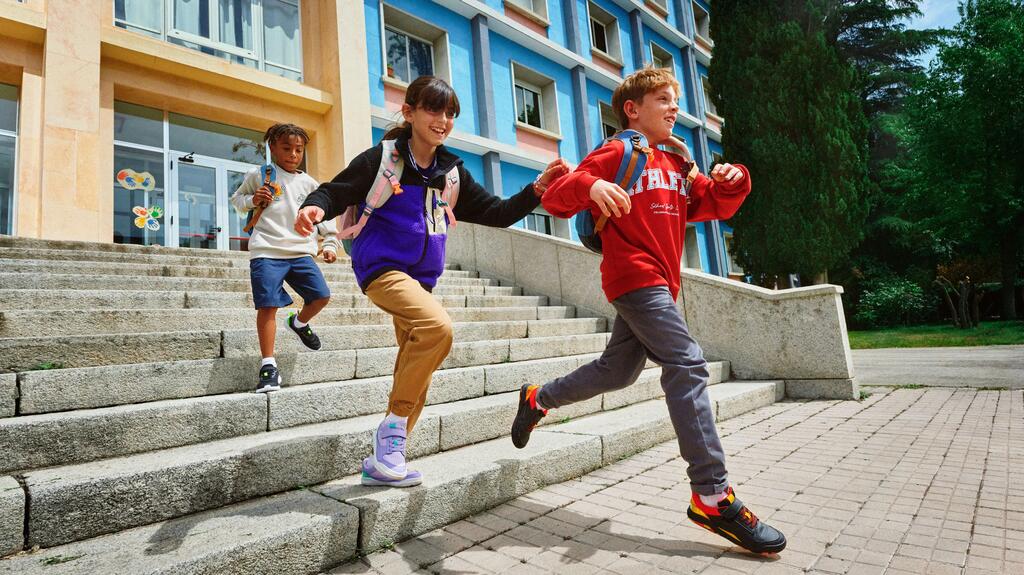 Kinder laufen aus dem Schulgebäude raus