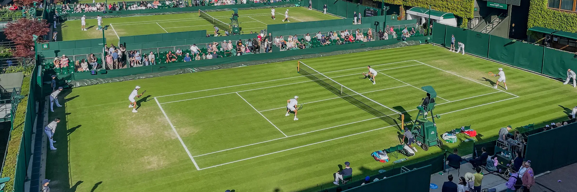 Tenisiści grający w tenisa na kortach Wimbledonu