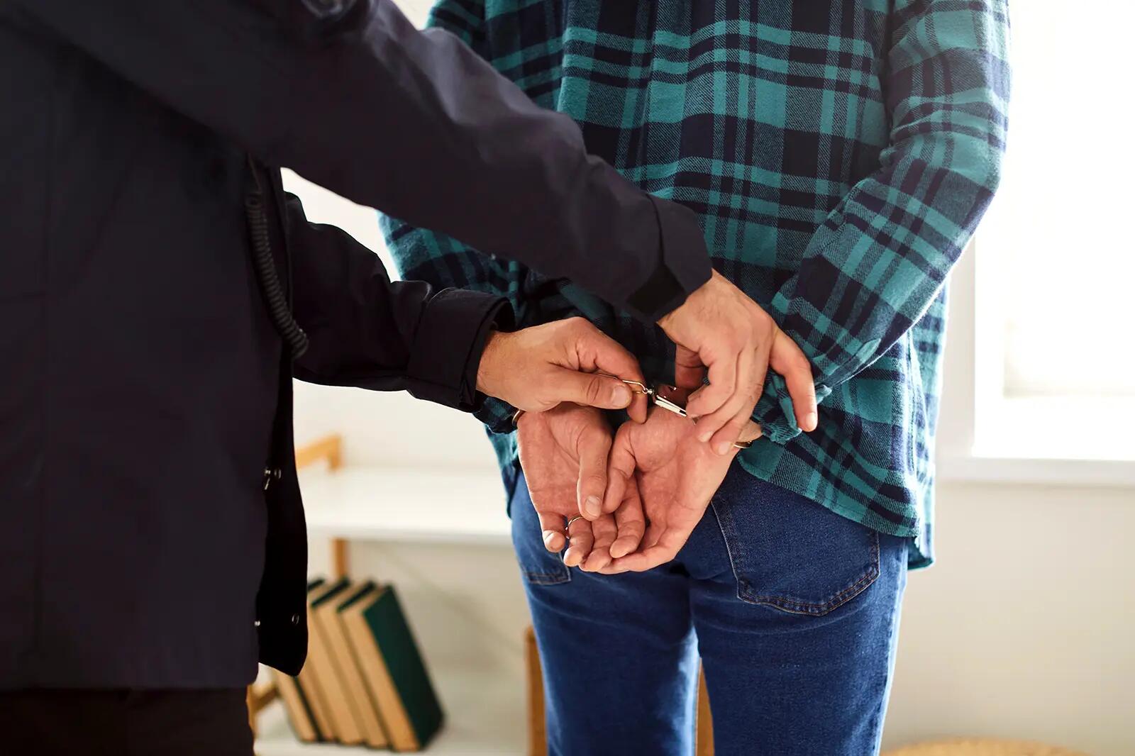 Policjant zakładający kajdanki mężczyźnie