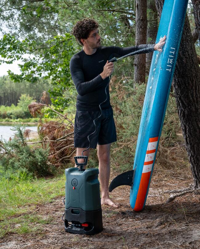 a user rinsing their paddleboard with the Decathlon portable cleaner