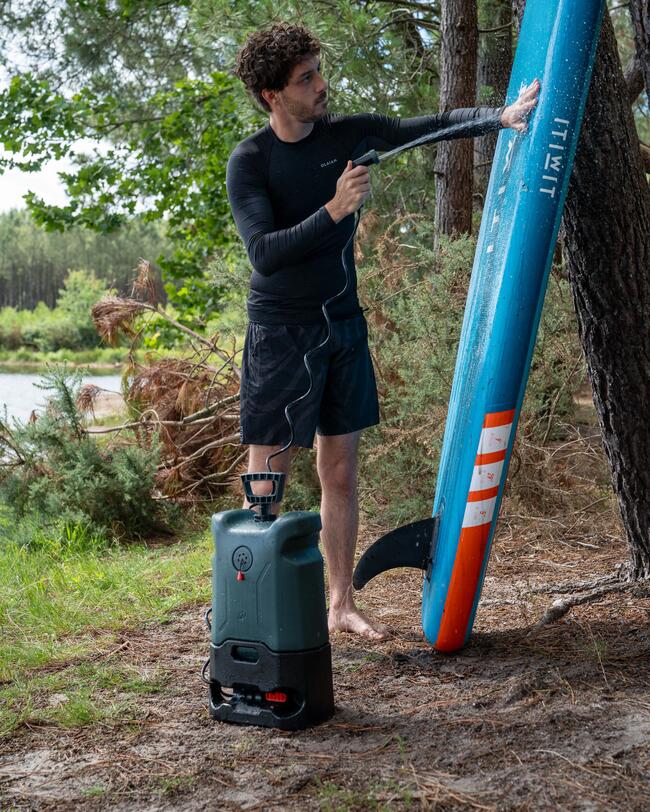 un utilisateur rince son paddle avec le nettoyeur nomade decathlon