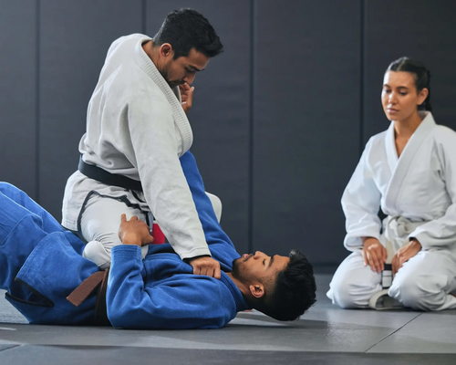 Kobieta sędziująca dwóch mężczyzn na macie w karate Kyokushin