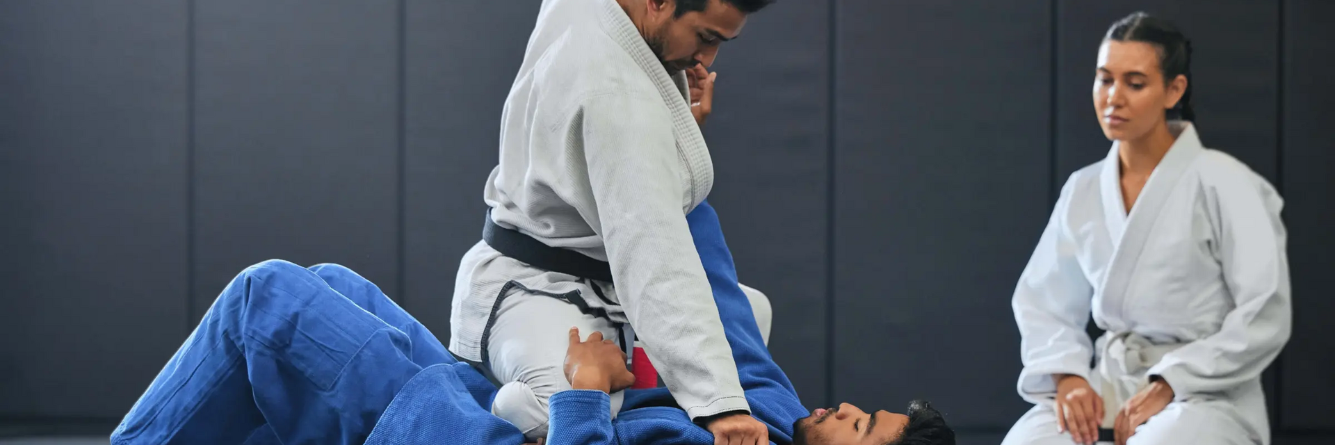 Kobieta sędziująca dwóch mężczyzn na macie w karate Kyokushin