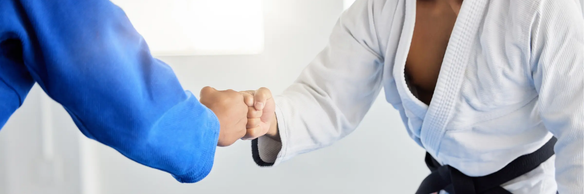 Dwóch mężczyzn witających się na macie przed treningiem karate