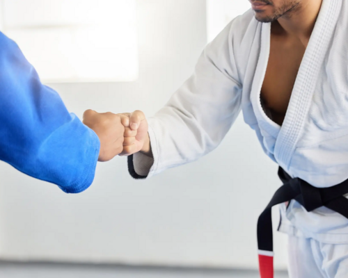 Dwóch mężczyzn witających się na macie przed treningiem karate