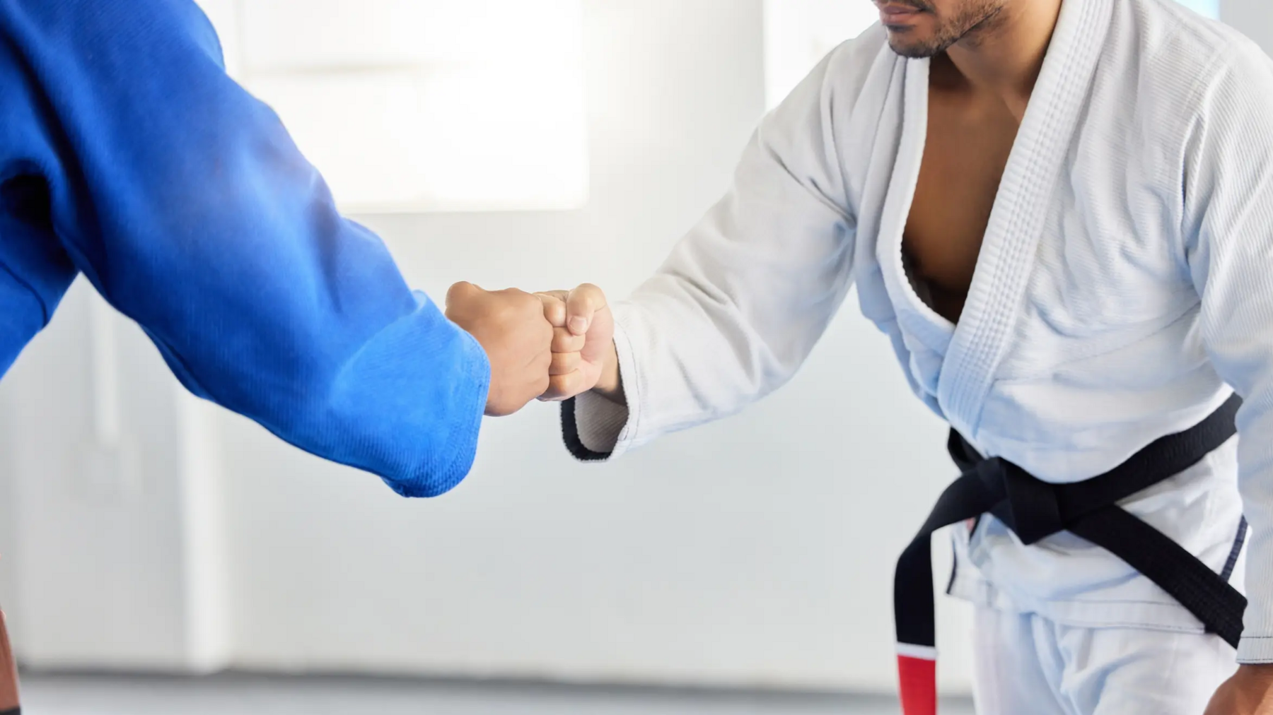 Dwóch mężczyzn witających się na macie przed treningiem karate