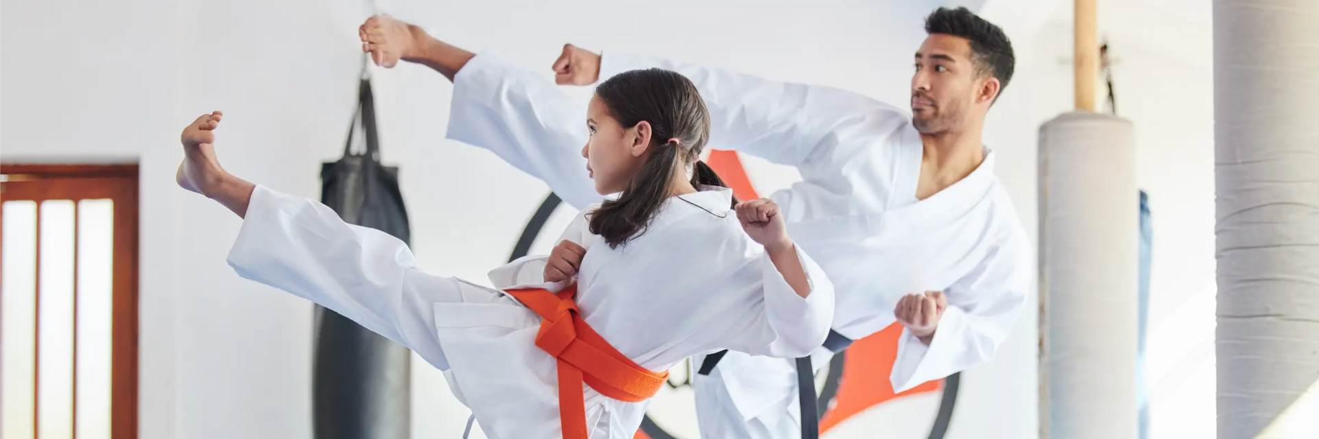 Dziewczynka z trenerem w karategach trenująca karate wydająca okrzyk kiai