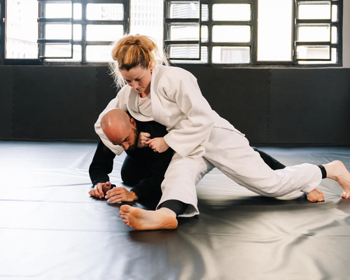 Mężczyzna i kobieta trenujący kate gatame w judo