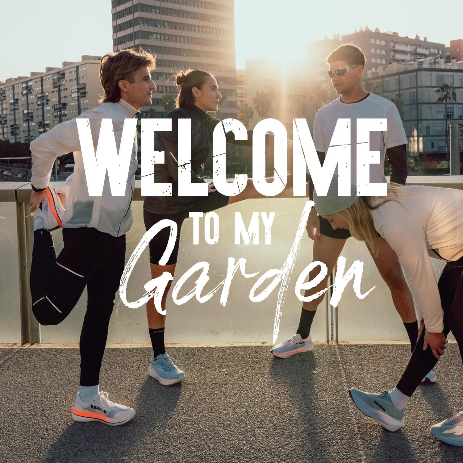Vier junge Läufer in Sportkleidung dehnen sich auf einem erhöhten urbanen Weg vor einer dichten Hochhaus-Stadtkulisse bei warmem Sonnenuntergangslicht. Ein großer weißer Text ist über das Bild gelegt und lautet: 'WELCOME TO MY Garden', wobei 'Garden' in geschwungener Schreibschrift geschrieben ist. Die Personen tragen moderne Laufschuhe und Laufbekleidung. Eine Frau trägt eine Beanie, ein Mann eine Sonnenbrille.