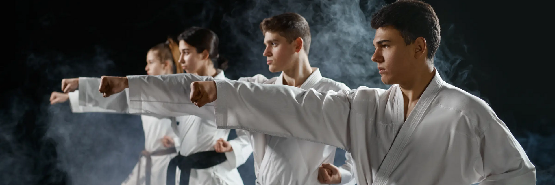 Osoby w karategach trenujące ciosy karate