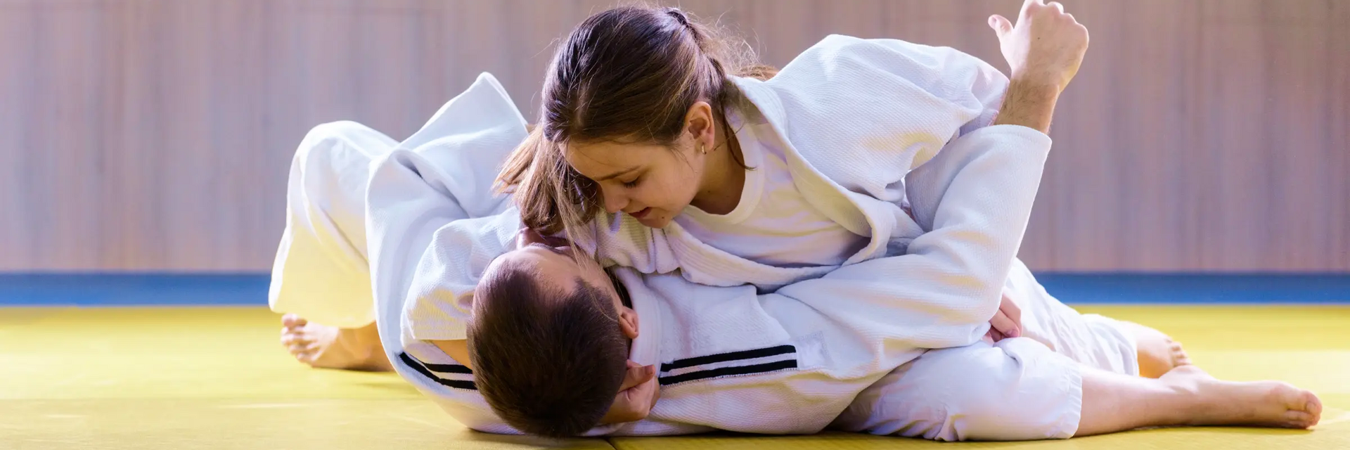 Kobieta trenująca z mężczyzną omoplata na macie