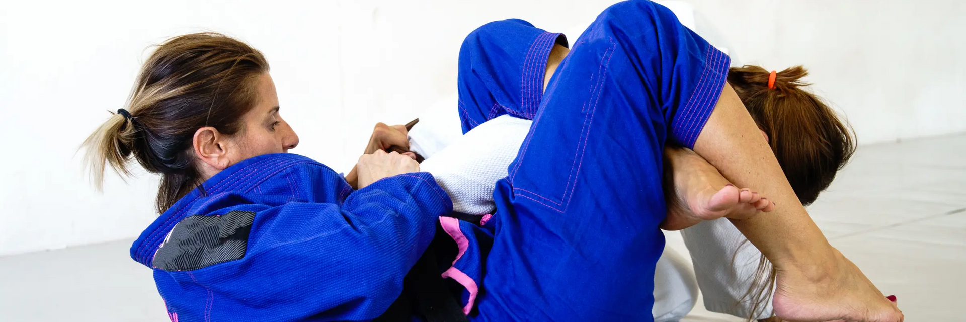 Dwie kobiety trenujące omoplata w judo