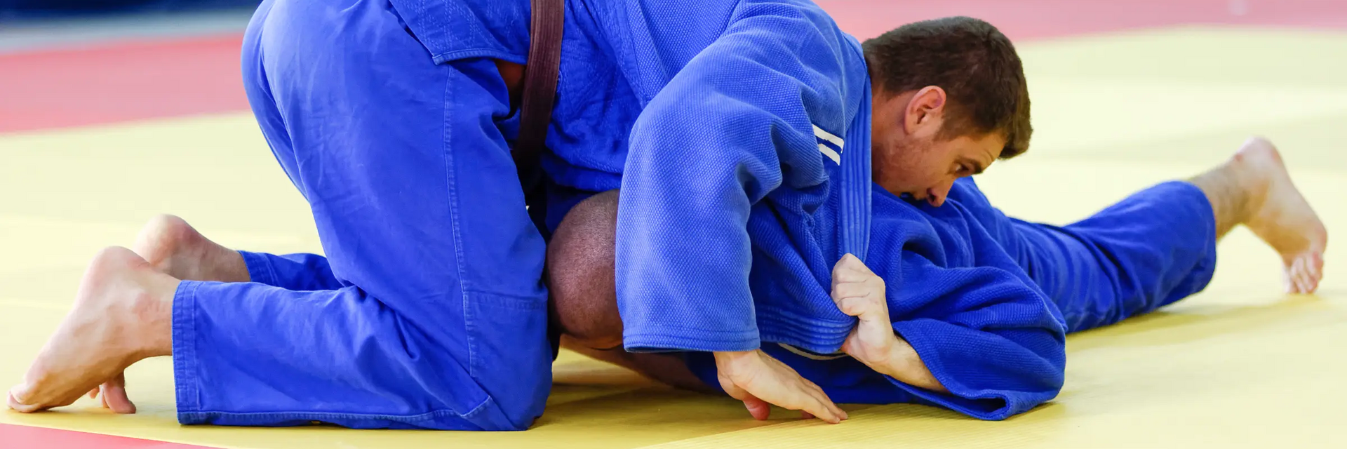 Mężczyźni trenujący omoplata na macie
