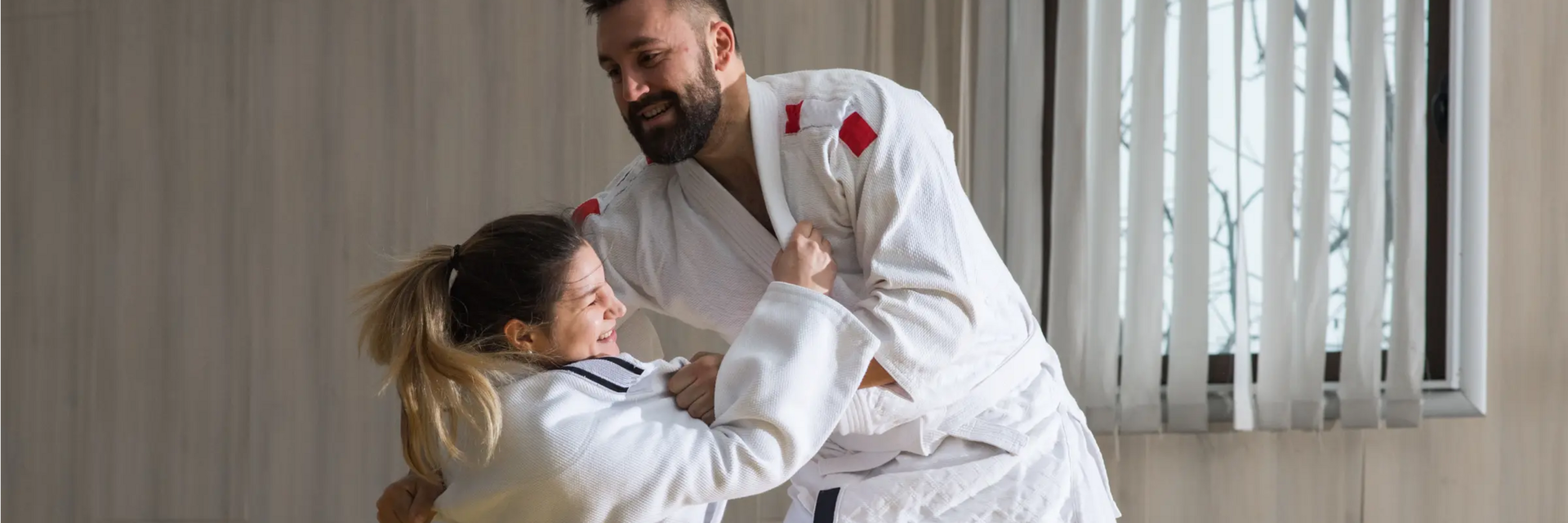 Kobieta z trenerem trenująca yoko otoshi w judogach