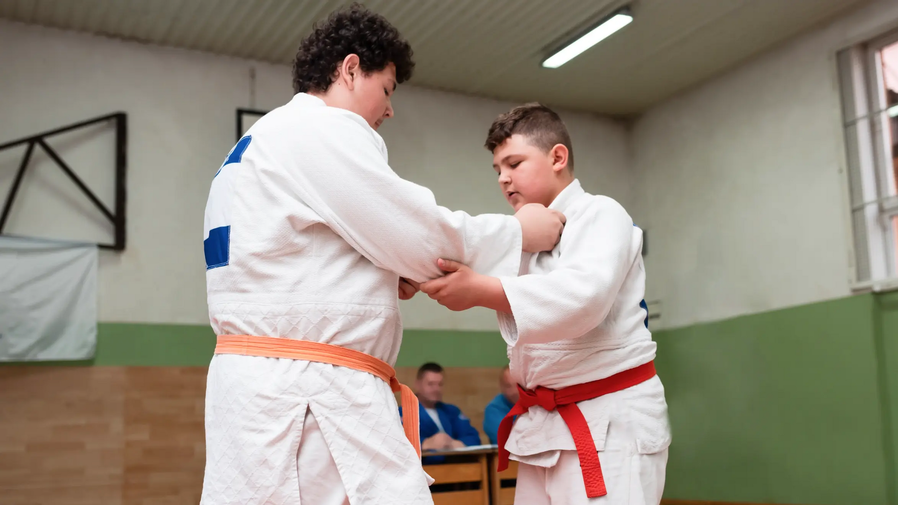 Dwóch chłopców w judogach trenujący tani otoshi