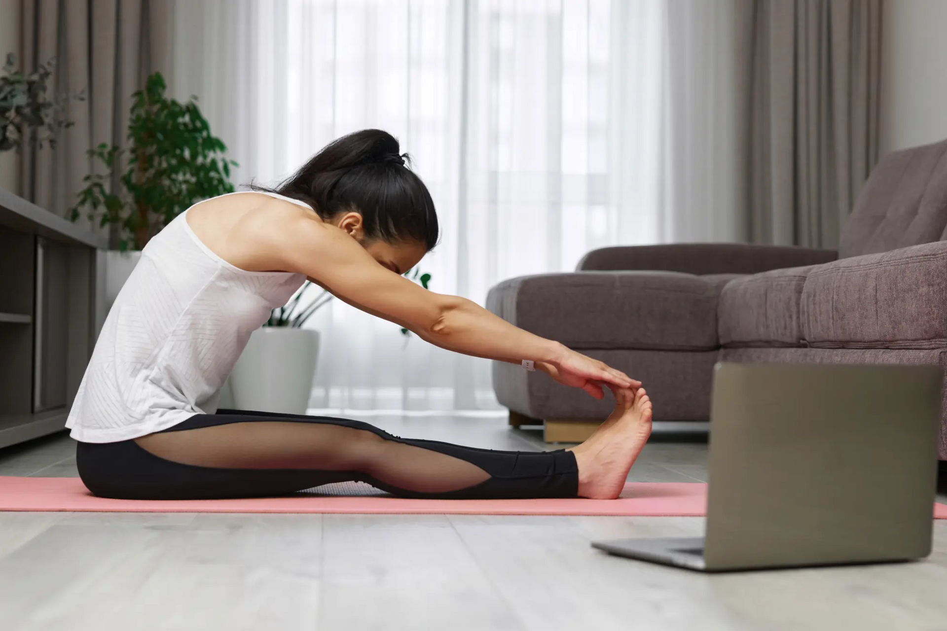 Kobieta siedząca na macie w pozycji spine stretch forward
