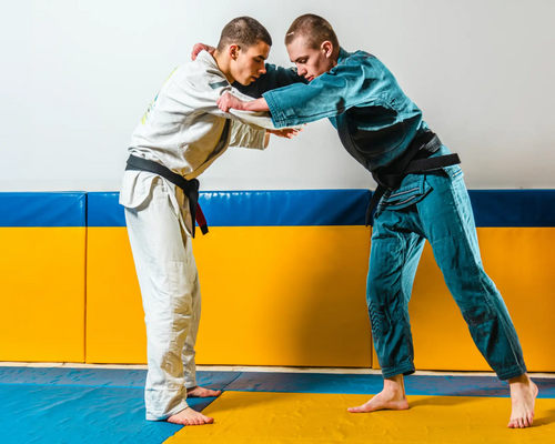 Chłopaki w judogach trenujący kuzushi w judo