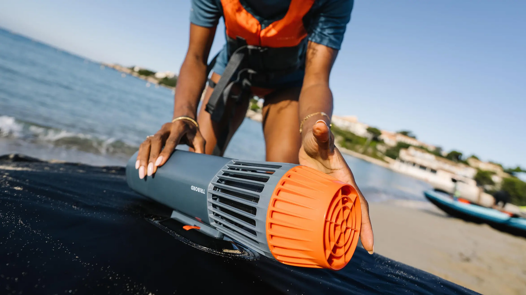 Kobieta montująca silnik elektryczny do kajka na plaży