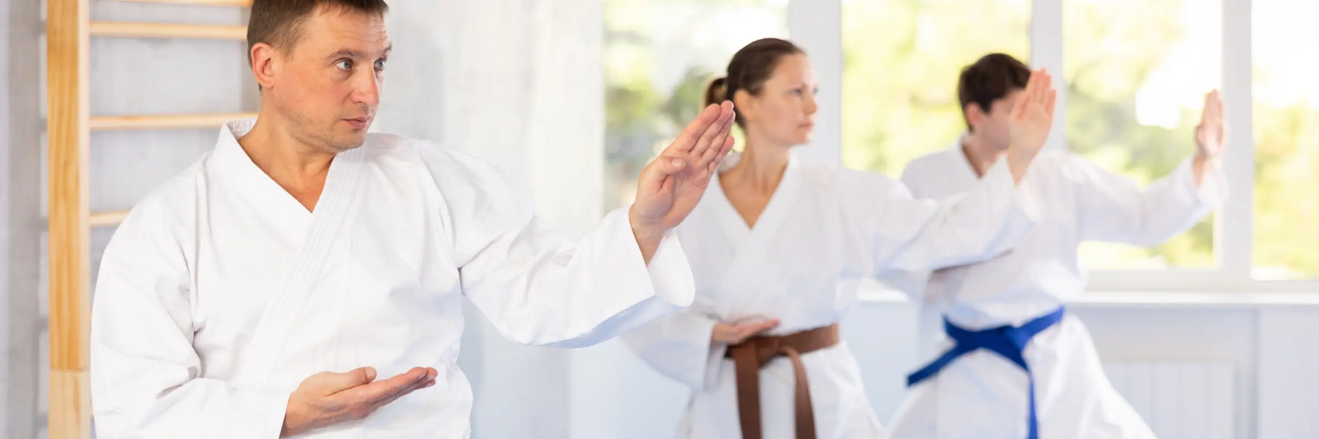 Troje ludzi w karategach trenujący kokutsu dachi w karate