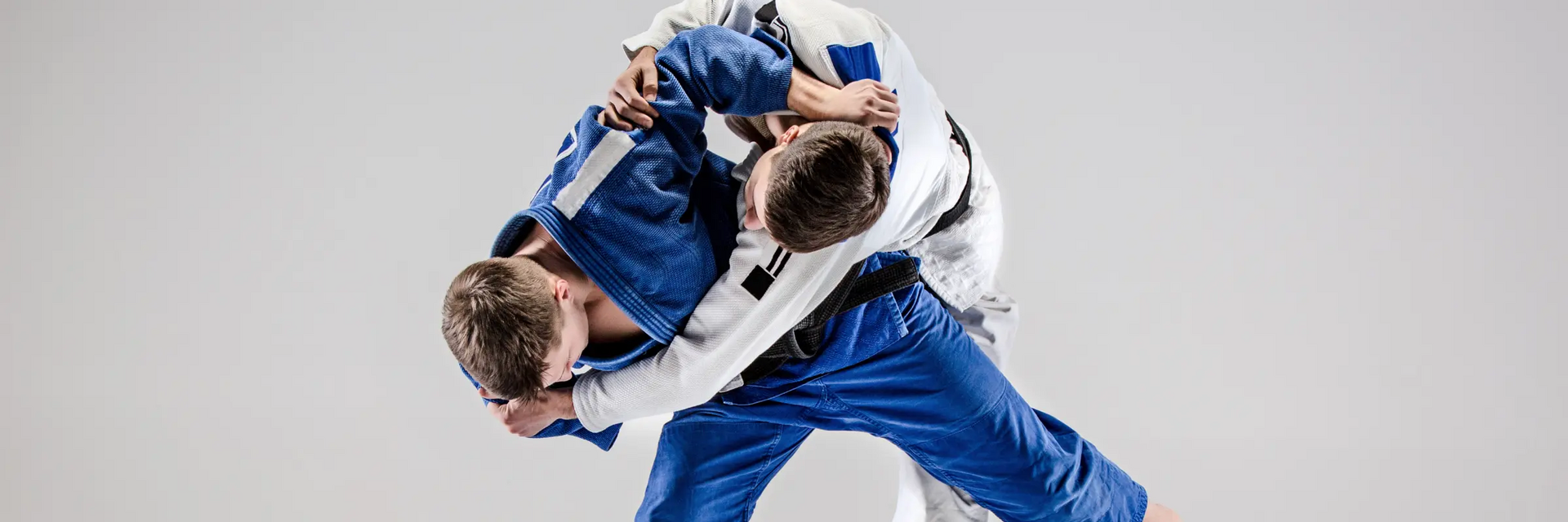Dwóch mężczyzn trenujących technikę uchi mata w judo