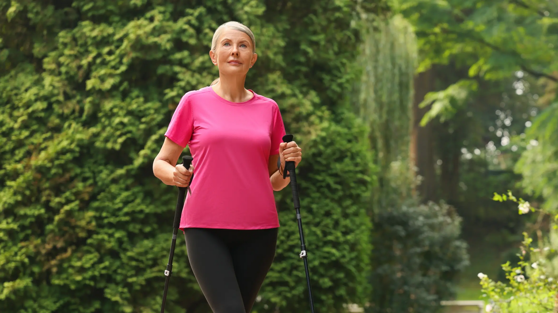 Kobieta uprawiająca nordic walking po lesie