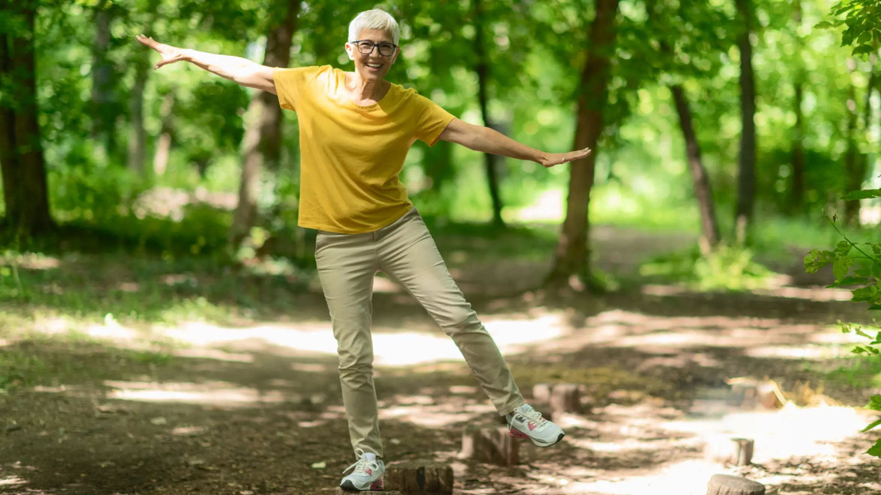 Seniorka stojąca na pieńku na jednej nodze 