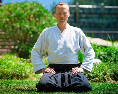 Mężczyzna ćwiczący aikido na trawie