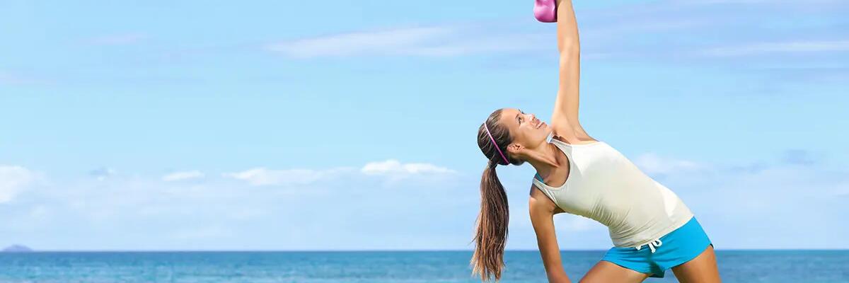 Kobieta wykonująca kettlebell windmill na trawie