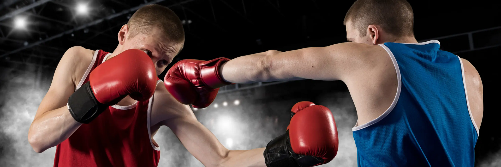 Dwóch mężczyzn w rękawicach bokserskich trenujący podstawowe techniki mma w ringu